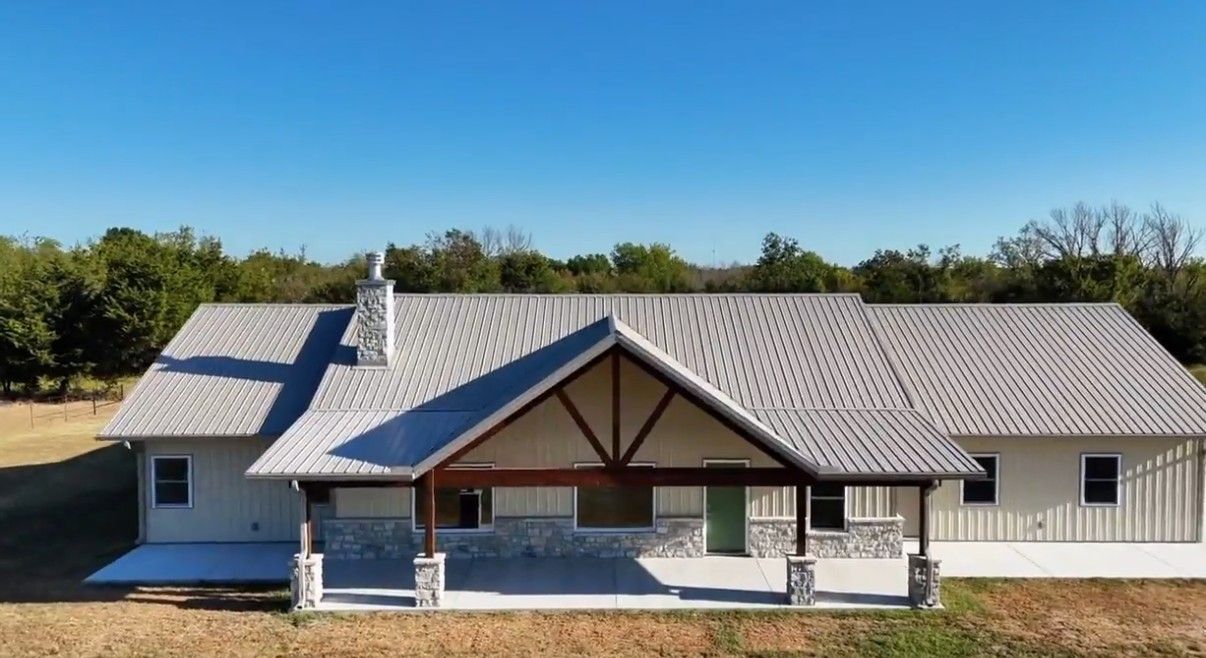 Finished home with metal roof, stone wainscot and timber gable porch